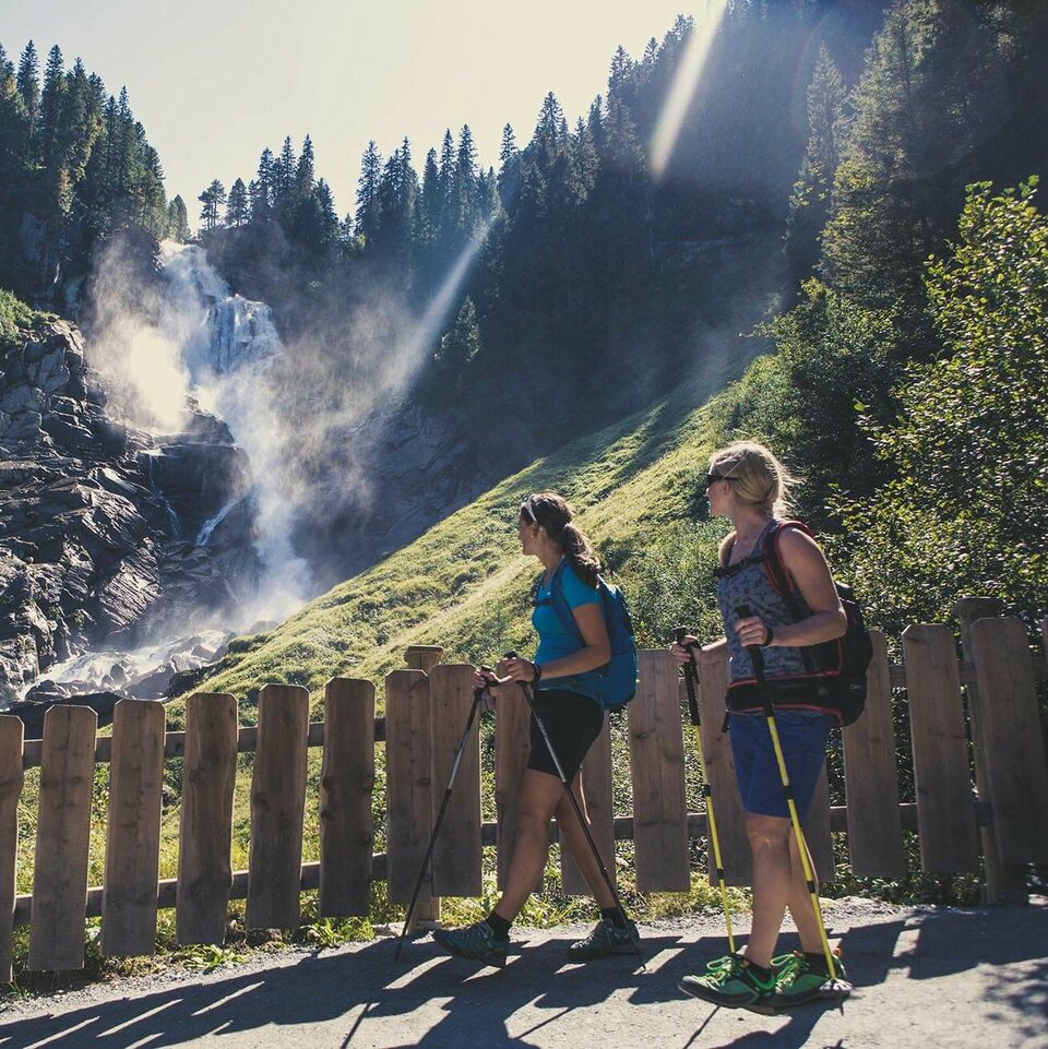 Zwei Wanderer beobachten einen Wasserfall