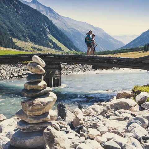 Zwei Frauen gehen über eine Holzbrücke