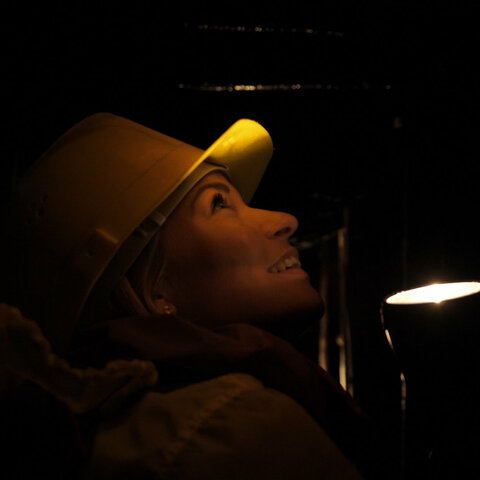 Eine Frau im dunklen Bergwerk