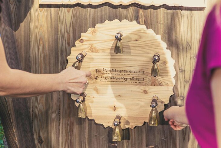 Auf einem Holzkreis befinden sich mehrere Glocken und ein Teil des Songtextes zu Stille Nacht.