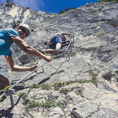 Personen klettern an einer Felswand im Erlebnisgarten Riederklamm