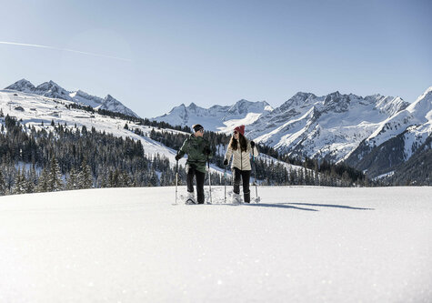 Ein Mann und eine Frau beim Schneeschuhwandern