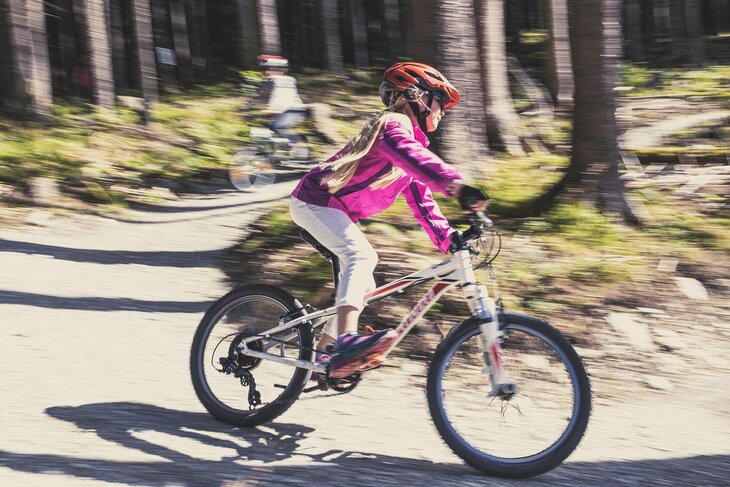 Ein Mädchen fährt auf einem Mountainbike durch den Wald
