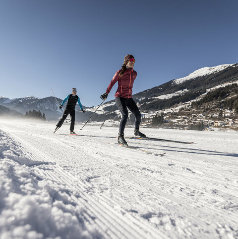 Zwei Langläufer auf einer verschneiten Strecke