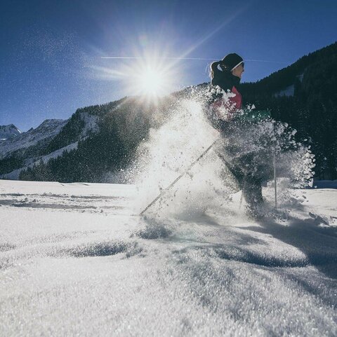 Eine Frau beim Schneeschuh wandern