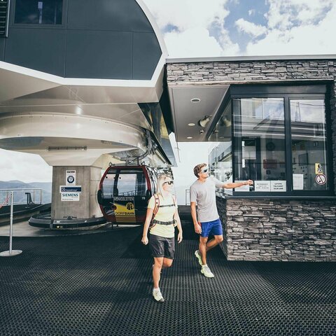 Ein älterer Mann und ein junges Paar bei einer Gondelstation