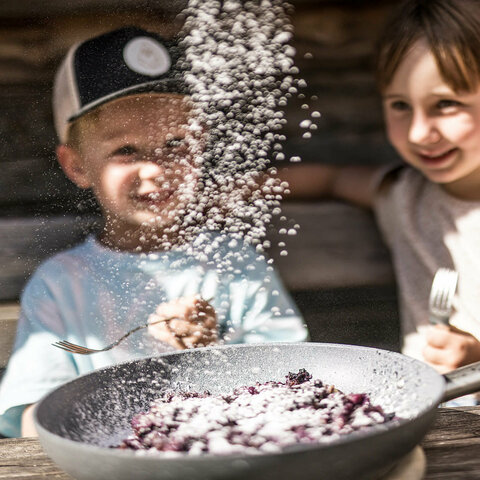 Ein Junge und ein Mädchen essen einen Kaiserschamarrn