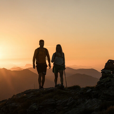 Ein Mann und eine Frau wandern beim Sonnenaufgang