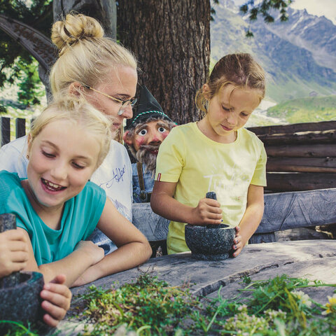 Eine Frau und drei Mädchen stampfen Blumen