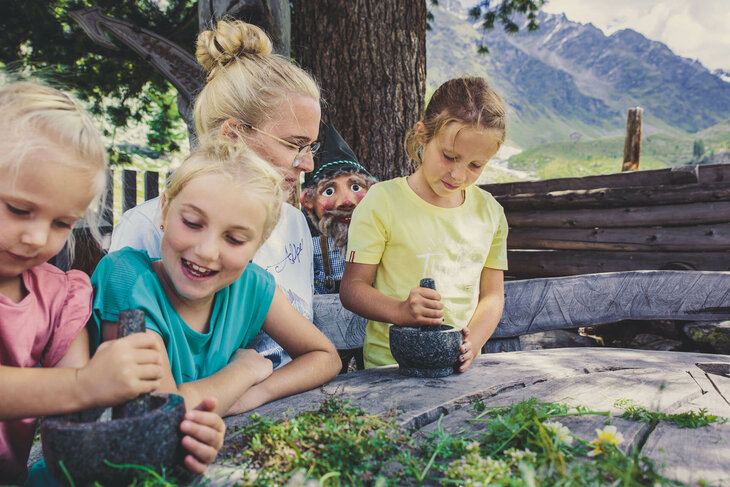 Eine Frau und drei Mädchen stampfen Blumen