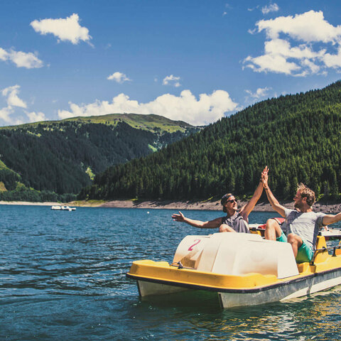 Zwei Männer fahren Tretboot auf dem Stausee