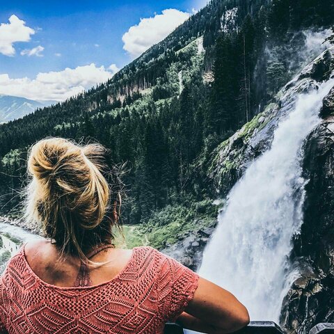 Eine Frau beobachtet einen Wasserfall