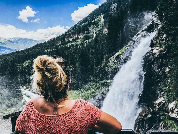 Eine Frau beobachtet einen Wasserfall