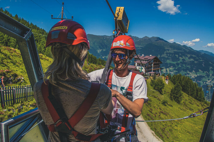 Ein Mann und eine Frau bereiten sich aufs Seilrutschen vor.