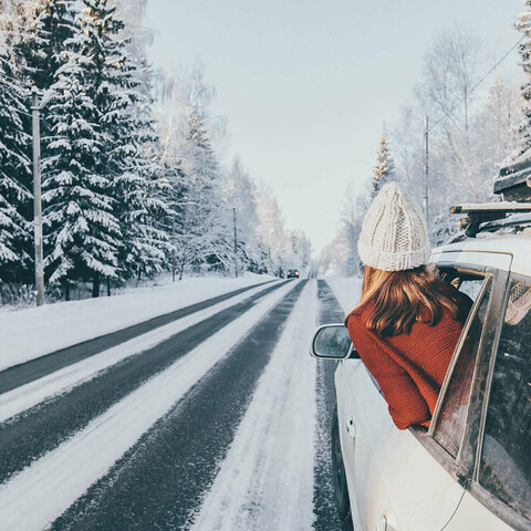 Eine Frau schaut aus dem Fenster eines Autos im Winter
