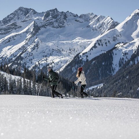 Ein Mann und eine Frau beim Schneeschuhwandern