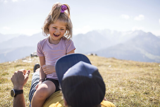 Ein Mann und ein kleines Mädchen spielen zusammen im Gras