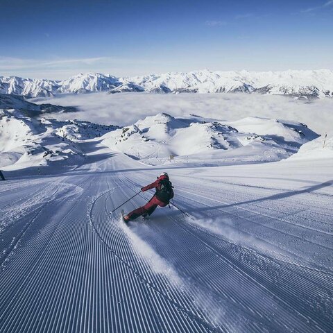 Ein Skifahrer fährt die Piste hinunter