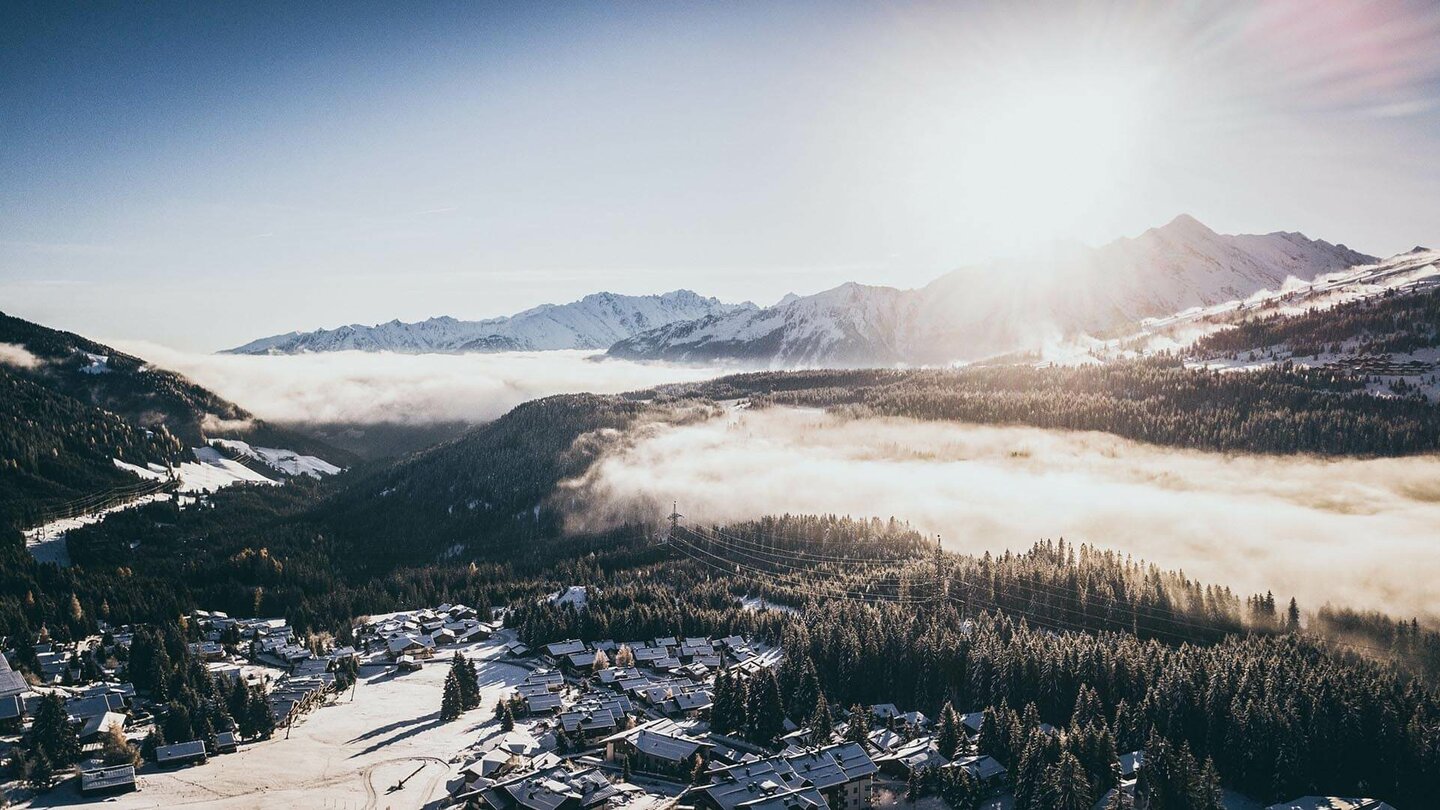 Blick auf eine traumhafte Winterlandschaft mit schneebedeckten Bäumen und einem klaren blauen Himmel