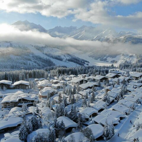 Blick auf ein schneebedecktes Dorf mit verschneiten Häusern und winterlichen Landschaften