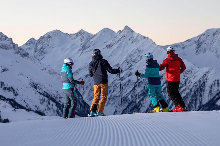 Vier Skifahrer stehen auf der Piste