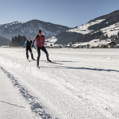 Zwei Langläufer auf einer verschneiten Strecke
