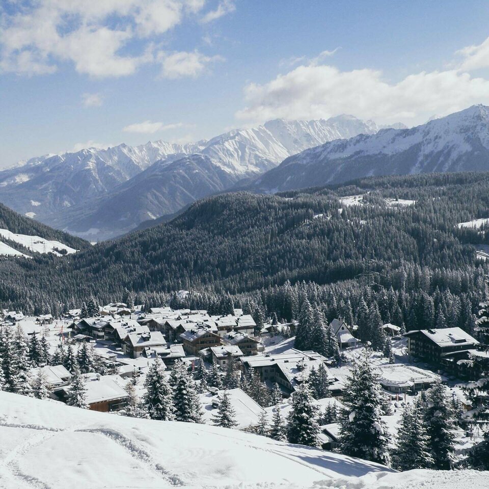 Blick auf ein schneebedecktes Dorf mit verschneiten Häusern und winterlichen Landschaften