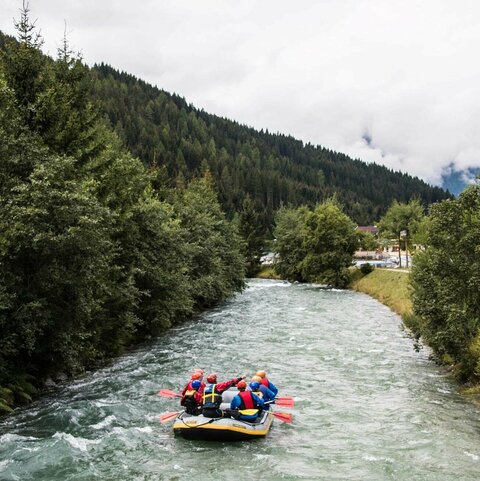Mehrere Personen machen eine Wildwasserbootfahrt.