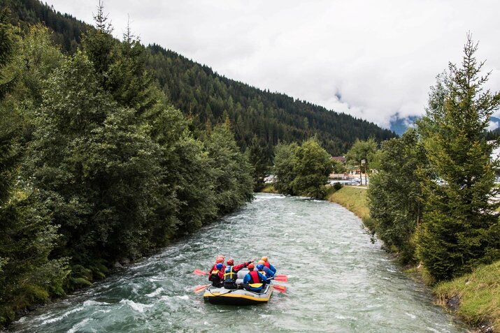 Mehrere Personen machen eine Wildwasserbootfahrt.