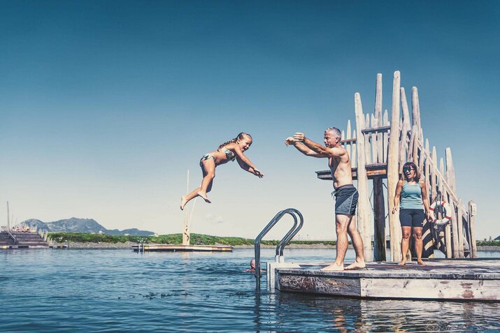 Mann wirft kleines Mädchen ins Wasser.