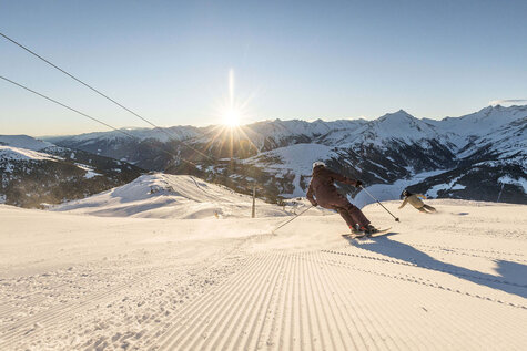 Zwei Skifahrer fahren die Piste hinunter