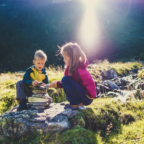 Ein Junge und ein Mädchen bauen einen Steinturm
