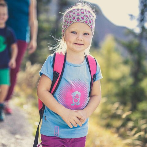 Ein kleines, blondes Mädchen beim wandern.