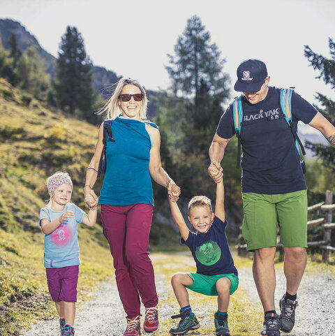 Ein Mann und eine Frau gehen Hand in Hand mit ihren Kindern.