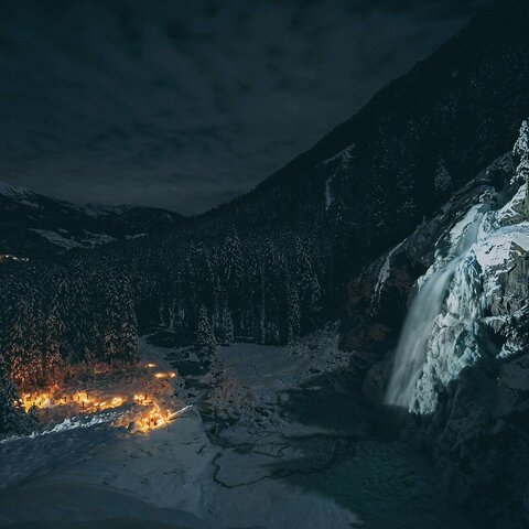 Mehrere Fackeln stecken nachts im Schnee