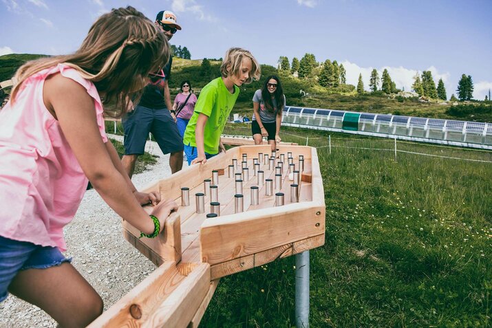 Eine Familie spielt mit einer Kugelbahn