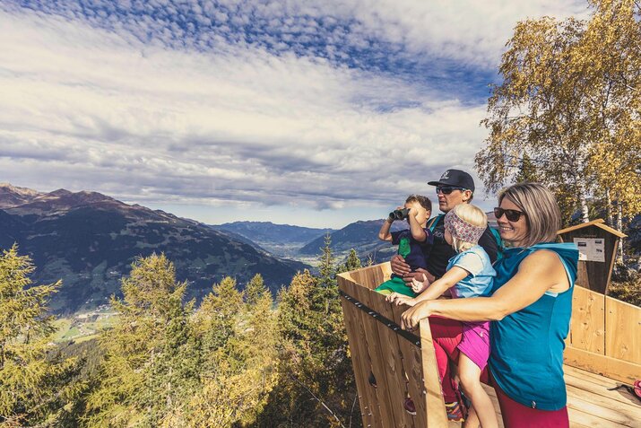Eine Familie steht an einem Aussichtspunkt.