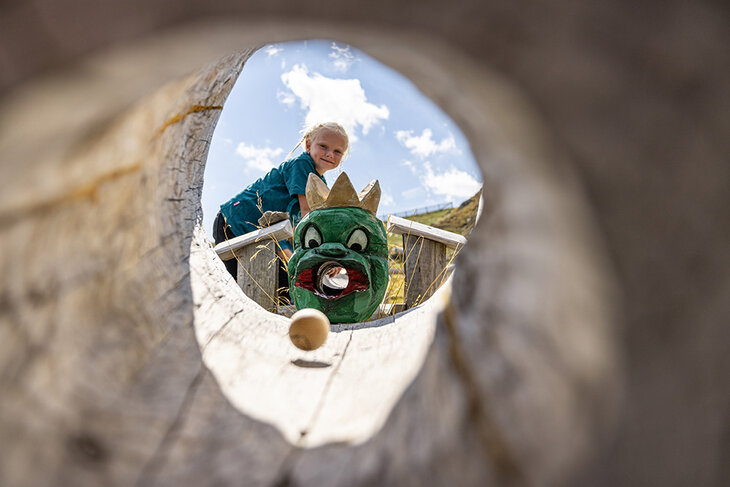 Ein Mädchen spielt mit einer Holzkugelbahn