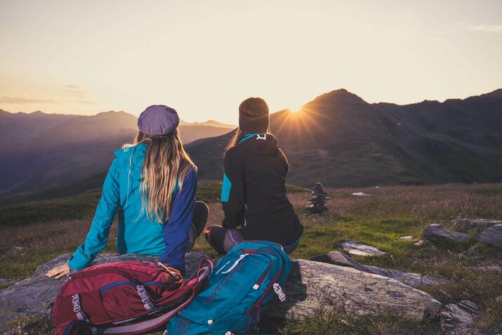 Zwei Frauen schauen sich einen Sonnenuntergang an