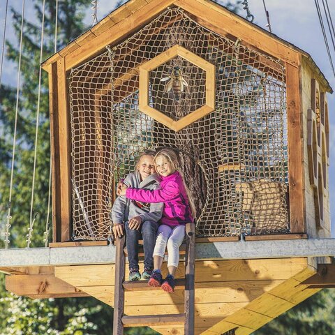 Themawandelpaden Zwei Mädchen sitzen auf einem Baumhaus