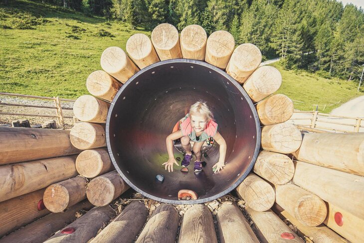 Kleines Mädchen spielt am Almspielplatz.