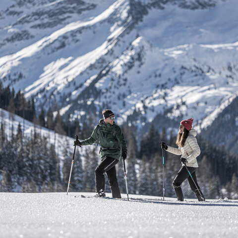 Ein Mann und eine Frau beim Schneeschuhwandern
