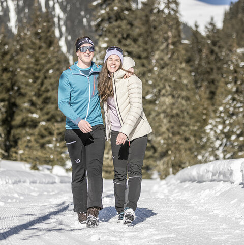 Ein Mann und eine Frau spazieren durch den Schnee