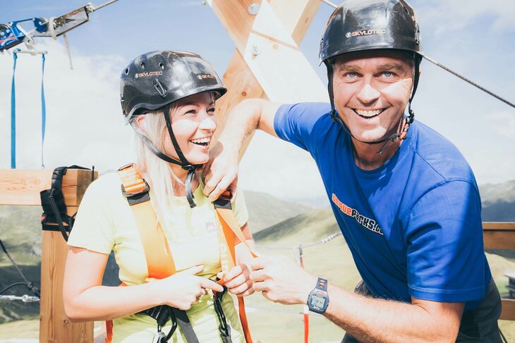 Eine Frau wird mit der Sicherheitsausrüstung für die Zipline ausgestattet